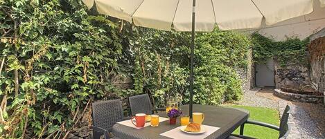 Charming patio garden, perfect for delightful outdoor dining #garden #patio #meals #umbrella