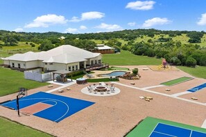 [Backyard] Half basketball court, pickleball, bocce, shuffleboard, a playground, heated pool, spa, and firepit