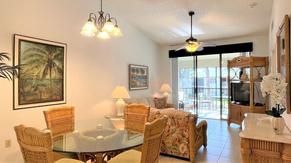 Dinning area with glass dining table and living area with tropical style setup