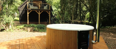 Quality Swedish wood fired hot tub and studio in background