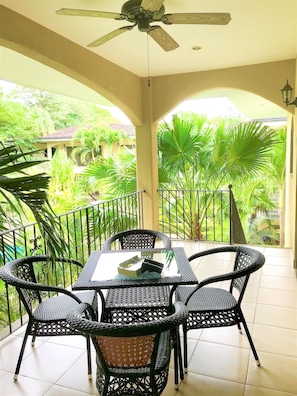 A private patio surrounded by lush greenery located right outside of our living room