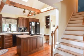 The kitchen has stairs that lead to the second-floor bedroom with a pair of twin beds.