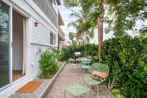 Private side yard with barbecue and string lights to enjoy the outdoors.