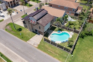 Aerial of the swimming pool & large private home.