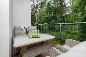Furnished balcony with green surroundings. 