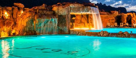Gorgeous pool and waterfall lit up at night