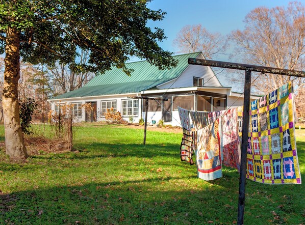 Looking up at the Sun Porch with 3 farm tables & our screened in Breakfast Porch