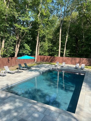 20' x 40' pool in the forest with jetted area in the back corner.