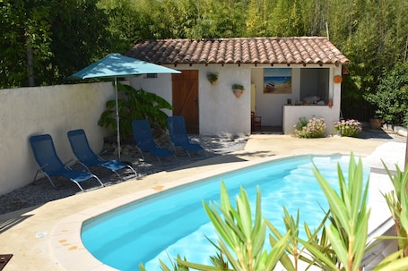La piscine avec son pool house.