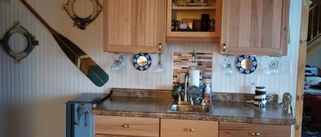 Wet bar in kitchen and wine refrigerator.