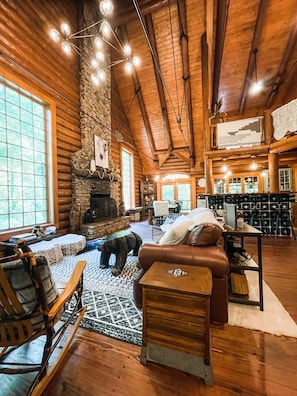 Main living/dining/kitchen area with hand carved bear coffee table and fireplace