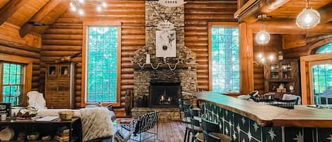 Main living area with soaring ceilings and stacked stone gas-burning fireplace.
