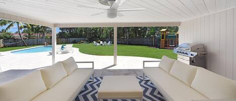 Large covered seating area with ceiling fan and BBQ