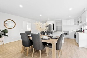 Open-plan dining with a 6-seater modern dining table that leads to the kitchen area.