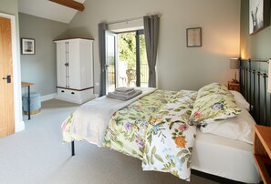 First floor: Bedroom with 5' king-size bed, en-suite shower room and doors leading out onto the balcony
