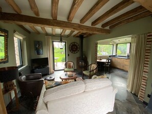 Salon confortable avec tv et vue sur le jardin.