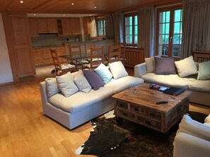 Overview of the living room, dining table, and open kitchen.