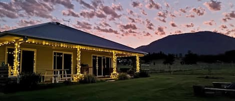 The cottage patio is lit by fairy lights at night!