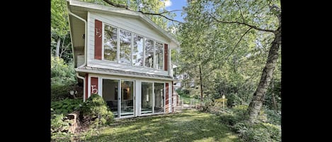 Front of house showing huge windows up and down showing picturesque lake views.