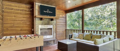 Amazing back patio with hot tub, lounge area, TV, fireplace, and a foosball table!