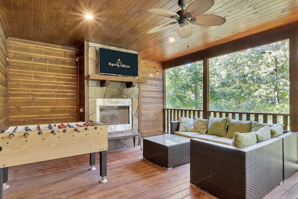 Amazing back patio with hot tub, lounge area, TV, fireplace, and a foosball table!