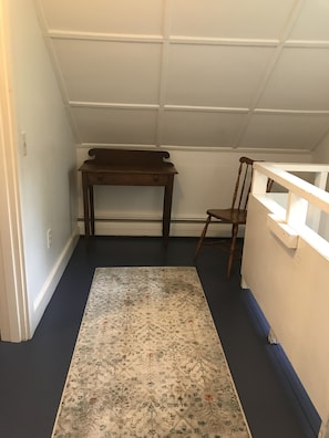 Upstairs hallway with small desk and chair for work.