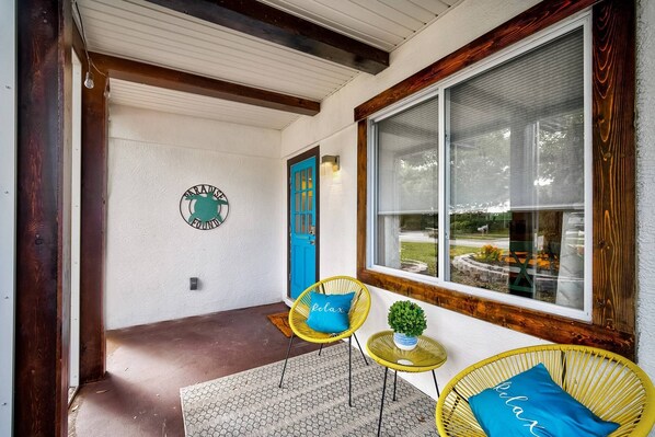 Tranquil sitting area in screened porch at front of the home.