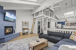 Loft with ladder up. Loft has another t.v., couch, and furry bean bag chairs. 