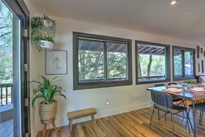 Dining area overlooking trees and large deck with French door access