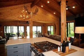 Spacious open kitchen, living, and dining spaces surrounded by lake views 