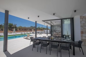 Shaded outside dining area with table and chairs to seat 10 people