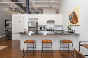 Cook and entertain in a sleek, fully-equipped kitchen featuring modern appliances, ample counter space, and all the essentials for a seamless dining experience in the heart of Fort Worth.