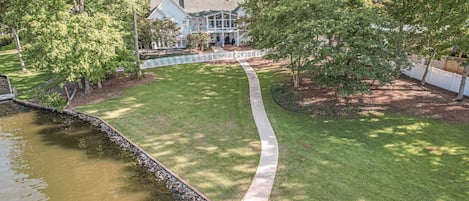 Back of house with paved walkway from house to dock 