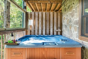 Private hot tub on lower deck with wooded view.