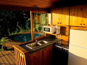Terrasse couverte avec cuisine équipée et vue sur l'océan et la piscine
