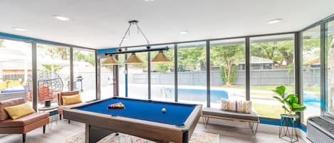 Gameroom/Sunroom area with a beautiful view of the pool and a pool table. 