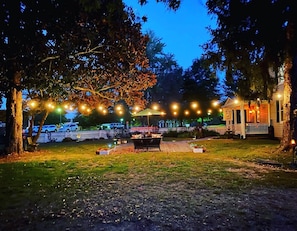 East patio with seating, tables, umbrella and cafe lights