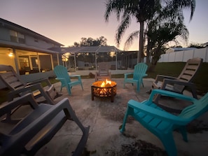 Cozy fire pit, string lights, & rocking chairs. Perfect for intimate gatherings