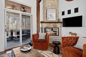 A grand floor-to-ceiling stone fireplace anchors the living room & is a perfect backdrop for family gatherings.