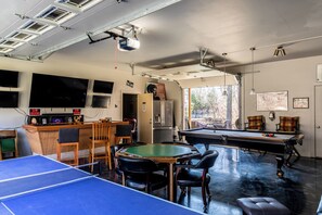 Garage game room with pool table, poker table, foosball, ping pong and 5 TVs!