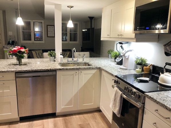 The heart of the apartment: The kitchen and living area, w/3 countertop chairs.