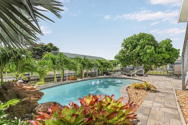 Beautifully landscaped pool area, lounges, table, outdoor shower, pool floats