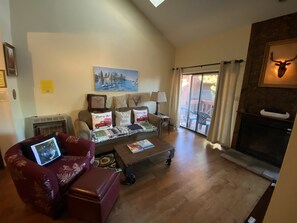 The living room with skylights and a glass door that leads to the patio. 