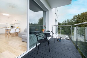 Spacious balcony with outdoor furniture and a green view