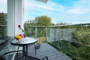 Spacious balcony with outdoor furniture and a green view