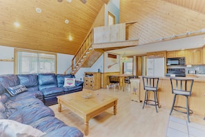 Another view of the living room showing the kitchen and bar seating.