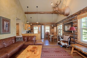 Large open floor plan with leather sectional, kitchen, and dining