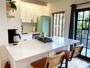Kitchen with gas cooktop, fridge/freezer, dishwasher, and barstool seating.