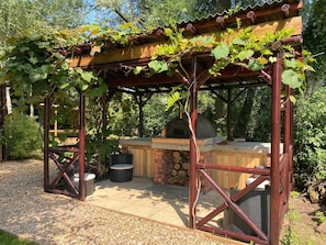 Vine covered outdoor Barbecue area with Pizza Oven.