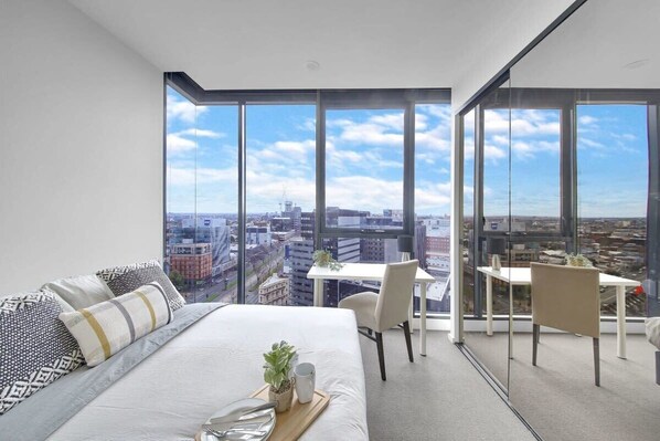 The master bedroom with a queen sized bed & a view over the city.